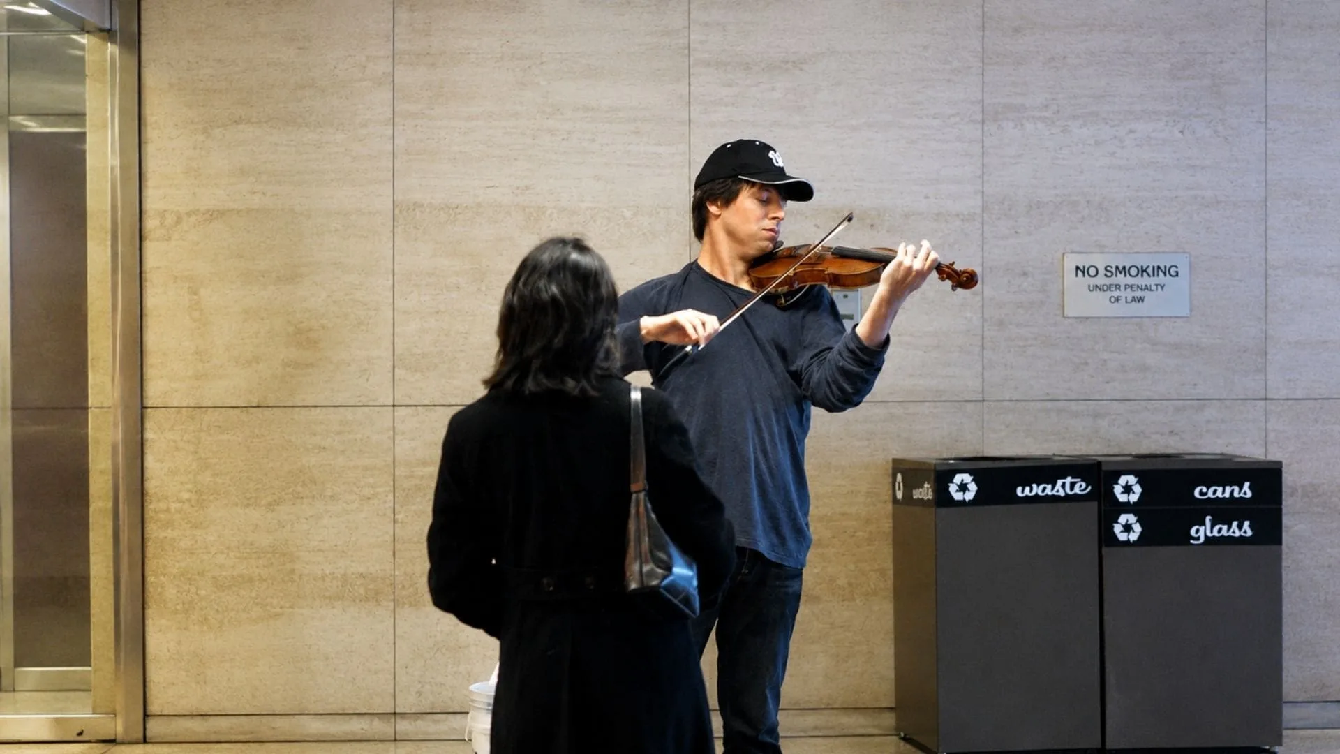 A violinist playing in a subway station while busy commuters pass by, inspired by the Joshua Bell experiment on perception and attention